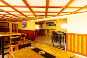 Cubita Guesthouse interior with tables, chairs, screens and design in wood and warm tones.