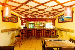 Cubita Guesthouse bar with stone bar, beverage shelf, stools and colorful decor.