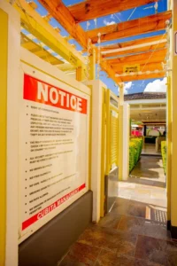 Cubita Guesthouse entrance with pergola, decorative lights and rules sign.