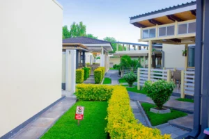 Landscaped area at Cubita Guesthouse with paved walkway, standards sign and modern architecture.